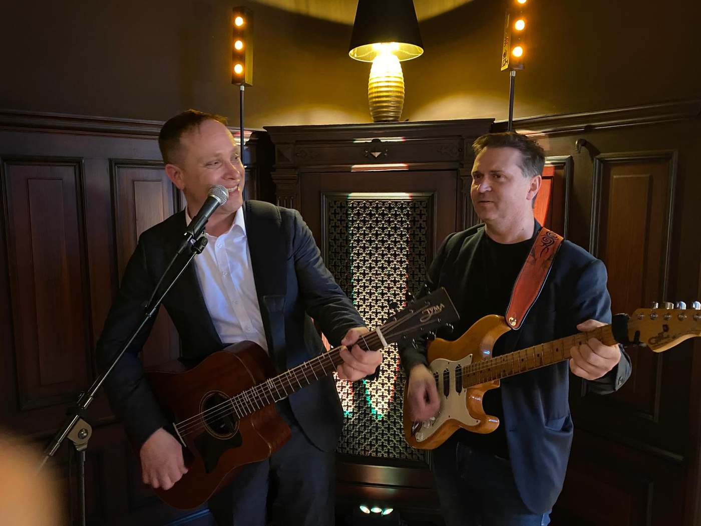 John Eid und ein weiterer Musiker spielen bei einer Hochzeitsfeier in einem eleganten Saal
